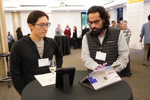 ATS instructional designer Mohammad Ahmed (right) demonstrates Poll Everywhere to Field Museum curator Richard Ree.