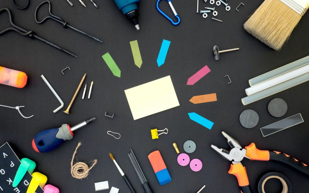 Various tools and office supplies on a black surface